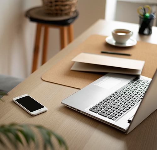 Bureau de travail avec Laptop, cellulaire, tasse à café et cahier de notes