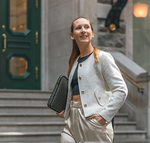 Pascale-Lou regardant au loin avec un laptop sous le bras